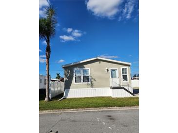 Tan single-wide manufactured home with white trim and a palm tree in the front yard at 919 50Th W Ave, Bradenton, FL 34207