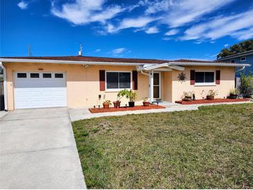 Charming single-story home featuring a well-kept lawn and an attached one car garage with a sunny sky at 10863 112Th Pl, Largo, FL 33778