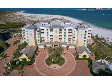 Stunning aerial view of a beachfront condo complex with beautiful landscaping, a circular driveway, and sandy beaches at 800 Collany Rd # 605 & 606, Tierra Verde, FL 33715