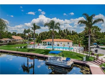 Community pool and boat dock area with lush landscaping at 2595 Cyprus Dr # 4-202, Palm Harbor, FL 34684