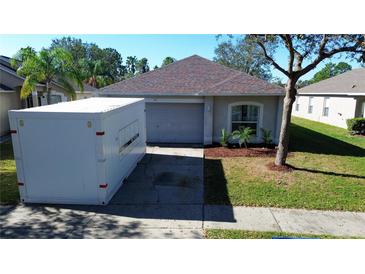 House exterior with a storage container, driveway, and landscaped yard at 10543 Opus Dr, Riverview, FL 33579