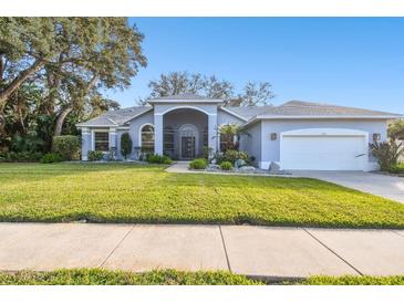 Single-story home with a landscaped lawn and attached garage at 1903 Gulf Beach Blvd, Tarpon Springs, FL 34689