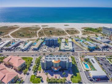 Aerial view of beachfront property, showcasing the building and surrounding beach at 11605 Gulf Blvd # 507, Treasure Island, FL 33706