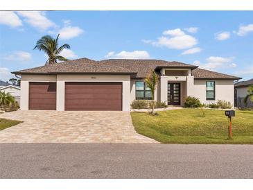 A charming single-story home with a two-car garage and well-manicured lawn at 15136 Hennipen Cir, Port Charlotte, FL 33981