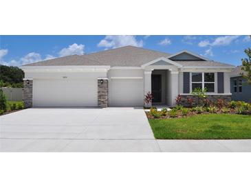 Charming single-Gathering home with a two-car garage, stone accents, and a well-manicured lawn and landscaping at 16030 10Th E Ave, Bradenton, FL 34212