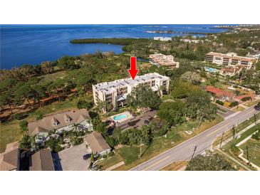 Aerial view of waterfront condo building with pool and parking at 206 Tarpon Pt, Tarpon Springs, FL 34689