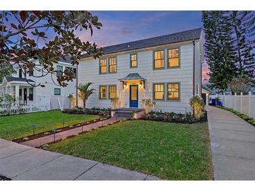 Two-story craftsman home with a charming front porch and well-manicured lawn at 2410 Woodlawn E Cir, St Petersburg, FL 33704