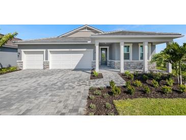 Beautiful single-Gathering home with a welcoming front porch and a well-manicured, landscaped yard at 18424 Vista Park Ter, Venice, FL 34293