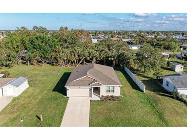 Aerial view of a single-story house with a large backyard and driveway at 3332 Elkcam Blvd, Port Charlotte, FL 33952