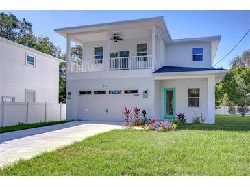 Two-story house with balcony, attached garage, and landscaped lawn at 515 Elm St, Safety Harbor, FL 34695