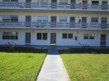 Front view of a two-story building with multiple balconies and a well-maintained lawn at 6000 20Th N St # 114, St Petersburg, FL 33714