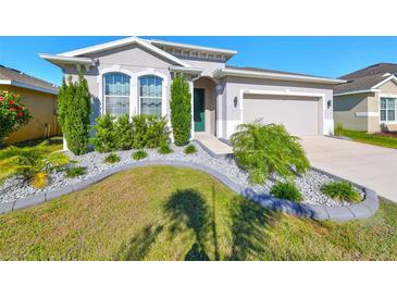 Charming single-story home featuring a beautifully landscaped front yard and a two-car garage at 12153 Ledbury Commons Dr, Gibsonton, FL 33534