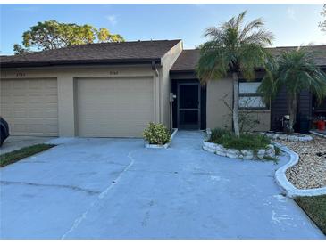 Two-car garage and front entry of condo with landscaping at 9744 Lake Seminole E Dr, Largo, FL 33773