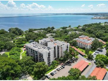 Aerial view of waterfront condo community with lush landscaping and parking at 2699 Seville Blvd # 605, Clearwater, FL 33764