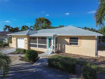 Inviting yellow house with screened porch, landscaped yard, and attached garage at 3873 21St N Ave, St Petersburg, FL 33713