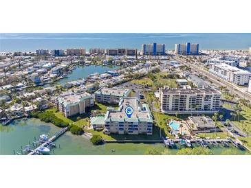 Aerial view of waterfront condo community with pool and boat docks at 399 150Th Ave # A203, Madeira Beach, FL 33708