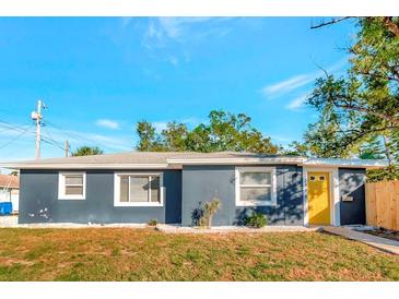 Newly renovated home with a charming yellow door and well-manicured lawn at 243 45Th N St, St Petersburg, FL 33713