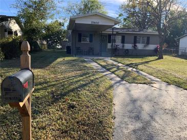 Gray exterior house with a covered porch and well-maintained lawn at 37400 Vista Dr, Dade City, FL 33523