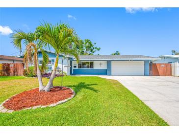 Charming single-story home featuring a lush, green lawn and a decorative palm tree at 1900 60Th N Way, St Petersburg, FL 33710