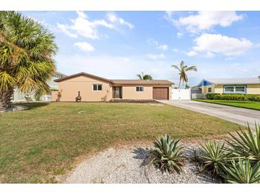 Updated single-story home with a spacious front yard and tropical landscaping at 5108 Commonwealth Rd, Palmetto, FL 34221