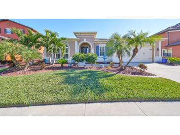 Single-story home with landscaped lawn and two-car garage at 13230 Fawn Lily Dr, Riverview, FL 33579
