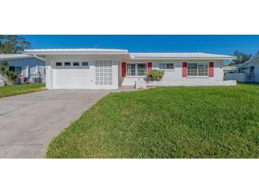 White house with red accents, attached garage, and well-manicured lawn at 14181 89Th Ave, Seminole, FL 33776