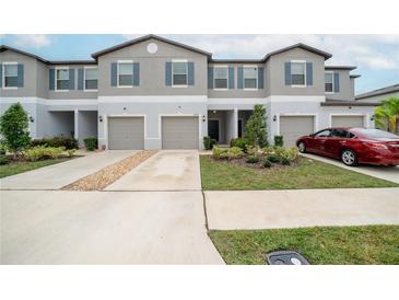 Two-story townhome with attached garage and landscaping at 9709 Pembrooke Pines Dr, Sun City Center, FL 33573