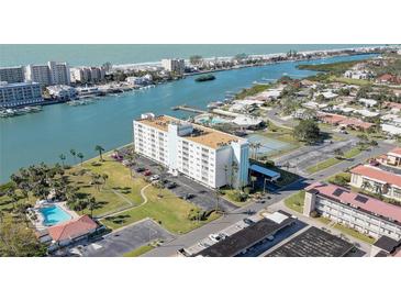 Aerial view of waterfront community, showing building, pool, tennis court, and waterway at 10216 Regal Dr # 603, Largo, FL 33774