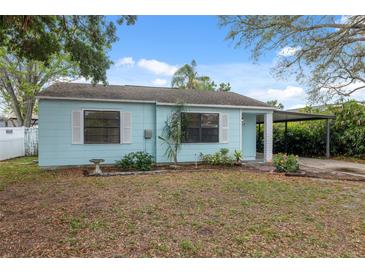 Quaint single-story home featuring light blue siding, white trim, and a covered carport at 3918 W Fig St, Tampa, FL 33609