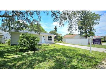 Charming single-story home featuring a well-maintained lawn and a driveway leading to a detached garage at 3562 Fisher Rd, Palm Harbor, FL 34683