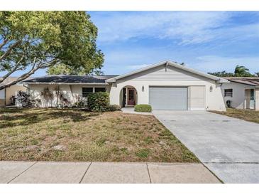 Single-story home with attached garage and well-maintained lawn at 2240 Colonial Dr, Dunedin, FL 34698