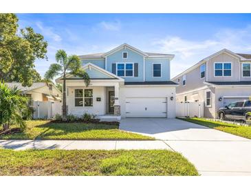 Two-story light blue house with a white garage door and landscaping at 1820 47Th N Ave, St Petersburg, FL 33714