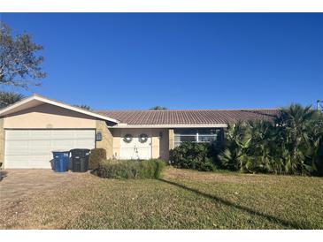 Single-story home with attached garage, double doors, and mature landscaping at 219 Leeward Is, Clearwater Beach, FL 33767