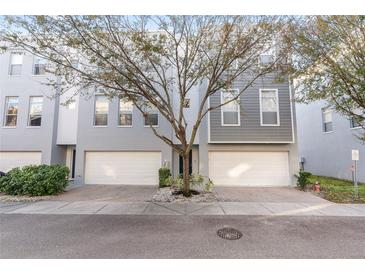 Modern two-story townhome with attached garage and tree-lined street at 4522 Bay Spring Ct, Tampa, FL 33611