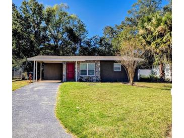 Updated Ranch home with carport, red door, and stone accents at 10018 N 25Th St, Tampa, FL 33612