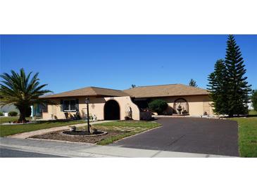 Single-story home with a large driveway and landscaped yard at 1727 Coco Palm Cir, Sun City Center, FL 33573