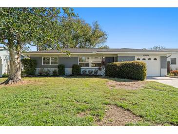 Gray single-story home with a white garage door and well-maintained lawn at 1993 59Th N Way, St Petersburg, FL 33710