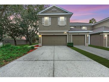 Two-story townhome with attached garage and landscaped front yard at 4010 Bismarck Palm Dr, Tampa, FL 33610