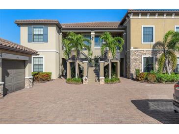 Two-story condo building with attractive landscaping and paved courtyard at 12610 Sorrento Way # 102, Bradenton, FL 34211