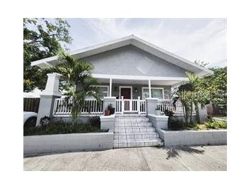 Charming house with gray siding, a white porch, and landscaped yard at 2912 W Main St, Tampa, FL 33607