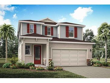 Two-story house with light beige siding, red accents, and a two-car garage at 31202 Pendleton Landing Cir, Wesley Chapel, FL 33545