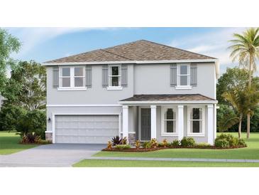 Two-story house featuring a gray exterior, landscaped lawn, and a two-car garage at 12071 Kingsley Trl, Parrish, FL 34219