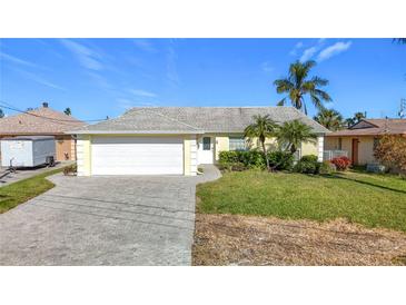 Cute yellow house with a large driveway and well-maintained lawn at 4603 Topsail Trl, New Port Richey, FL 34652