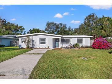 Charming single story home with a landscaped lawn and driveway at 12690 Palm Dr, Largo, FL 33774