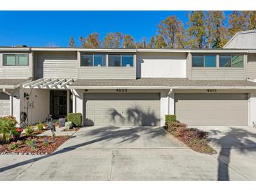 Two-story townhome with attached garage and landscaping at 4253 Golf Club Ln, Tampa, FL 33618