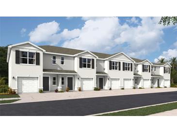 Exterior view of townhomes with attached garages and landscaping at 17440 Haysack Ter, Lakewood Ranch, FL 34211