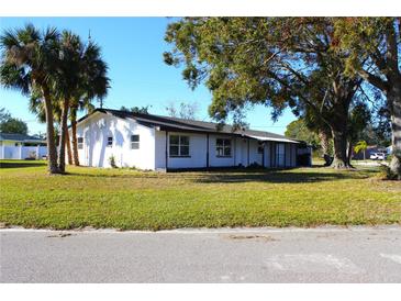 White single story home with a large front yard and mature trees at 212 Francis Dr, Apollo Beach, FL 33572