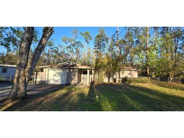 Cozy single-story home featuring a front yard, attached garage, and neutral paint scheme at 6906 Quail Hollow Blvd, Wesley Chapel, FL 33544