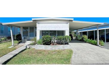 Single-wide manufactured home with carport and landscaped front yard at 18675 Us Highway 19 N # 232, Clearwater, FL 33764