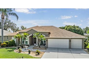 Single-story home with a two-car garage and landscaped front yard at 2048 Edelweiss Loop, Trinity, FL 34655